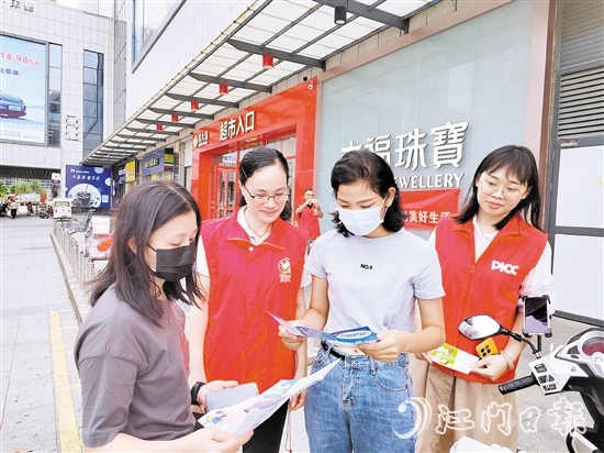 恩平人保財險工作人員向群眾派發(fā)宣傳折頁，普及金融知識。