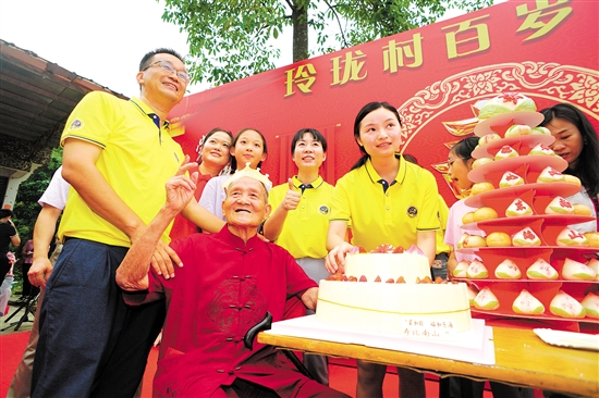 董淑猛（前排左一）、徐娜（豎大拇指者）等人為梁如旺老人慶祝百歲生日。