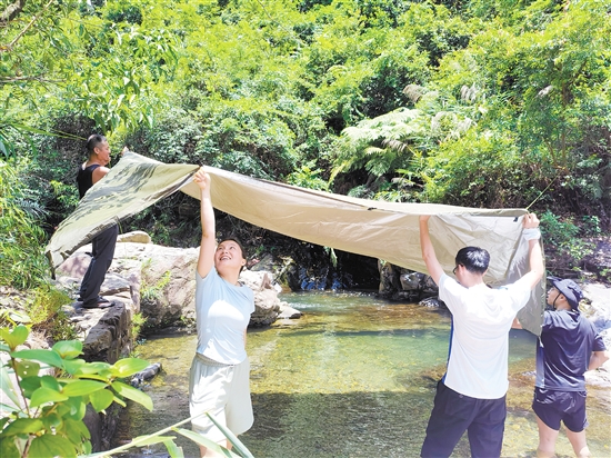 夏季，市民在戶外露營時搭棚防曬。