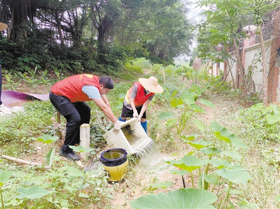 工作人員清理環(huán)境積水。