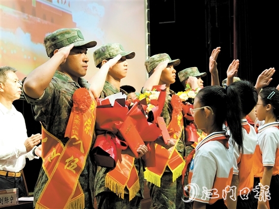 小學(xué)生代表向入伍新兵代表獻(xiàn)上鮮花。