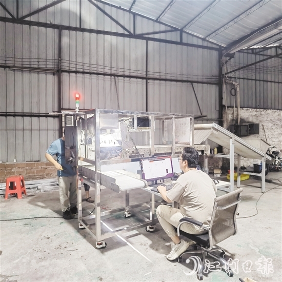 鷹視光電工作人員正在對AI視覺檢測設(shè)備進(jìn)行調(diào)試。