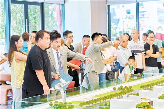 在駿景灣·品悅，銷售人員忙著為客戶介紹樓盤情況。