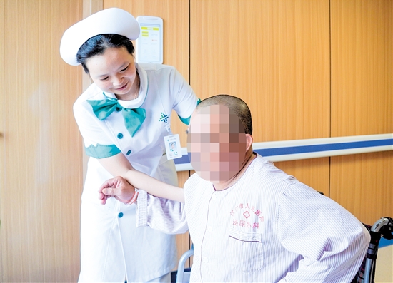 護士攙扶雙下肢無力患者上病床。