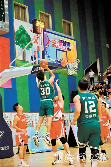萬村籃球賽江門市級(jí)賽決賽現(xiàn)場(chǎng)，橫江村隊(duì)隊(duì)員迎著防守跳投得分。
