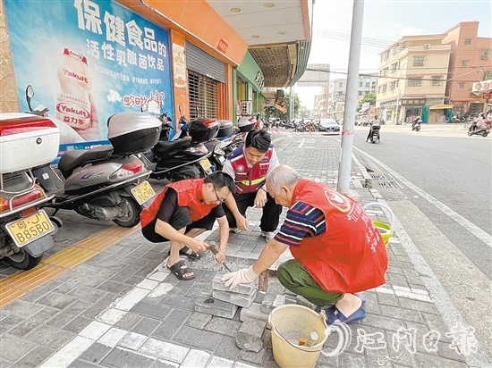 網(wǎng)格員和志愿者一同修復(fù)路面。