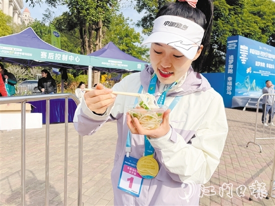 恩平溫泉半程馬拉松女子組冠軍郭利亞品嘗恩平瀨粉并點贊。