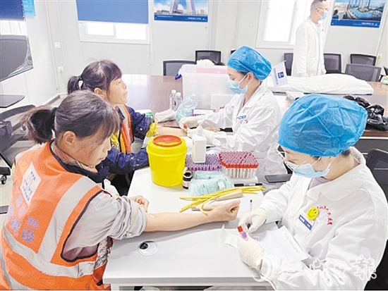 醫(yī)護(hù)人員為工友進(jìn)行身體檢查。