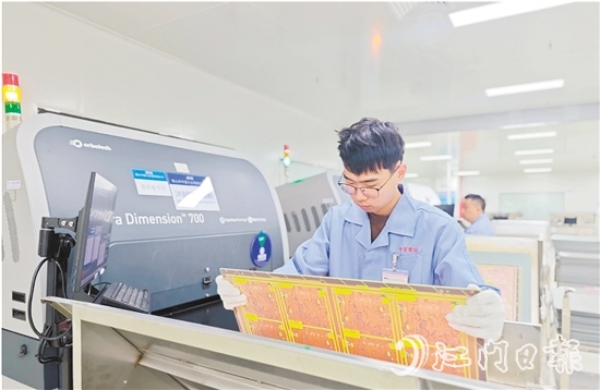 在鶴山中富生產(chǎn)車間，員工操作自動(dòng)化設(shè)備趕制電路板。