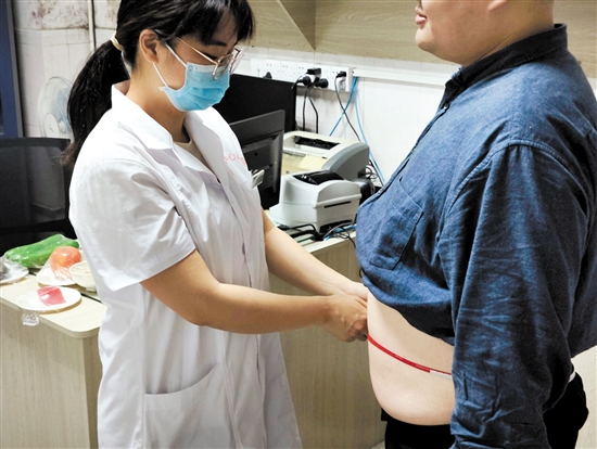 醫(yī)生為記者測(cè)量腰圍。