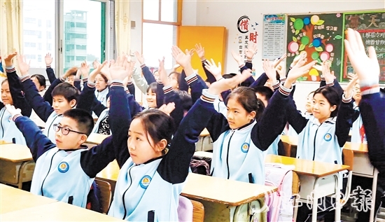 學(xué)生們在課桌前跟隨節(jié)奏做起“室內(nèi)課桌操”。