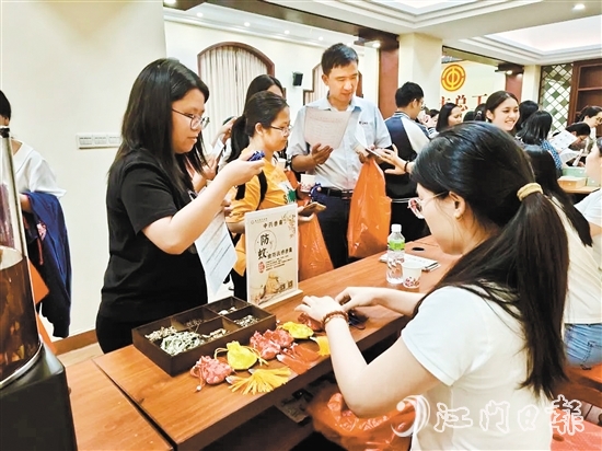 職工們與醫(yī)生探討中藥的成分和比例，制作防感驅(qū)蚊中藥香囊。