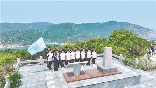江門市青年學生國家安全志愿者宣傳隊成員在江門圍夾島領?；c為領海界碑描紅。