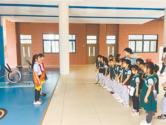 紅領(lǐng)巾講解員帶領(lǐng)孩子參觀校園。