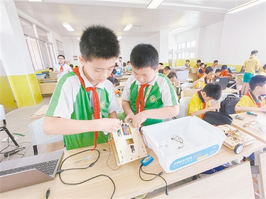 賽場上，小選手們?nèi)褙炞⒌剡M行機器人編程與調(diào)試。