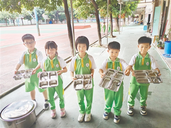 沙坪街道第三小學(xué)舉辦“光盤行動”主題活動，學(xué)生展示“光盤”成果。