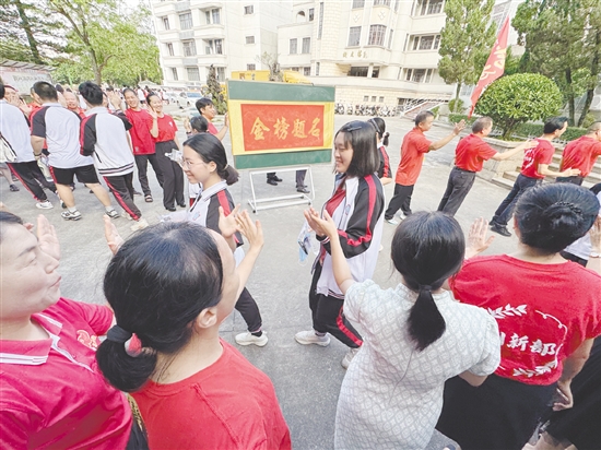臺(tái)山一中在送考路上設(shè)置了“金榜題名”大字帖，教師身穿紅衣與學(xué)生擊掌，為學(xué)生加油。