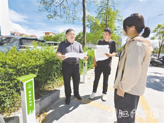 余中宏（左一）與同事一起查看“民生服務(wù)充電站”項目建設(shè)進(jìn)度。