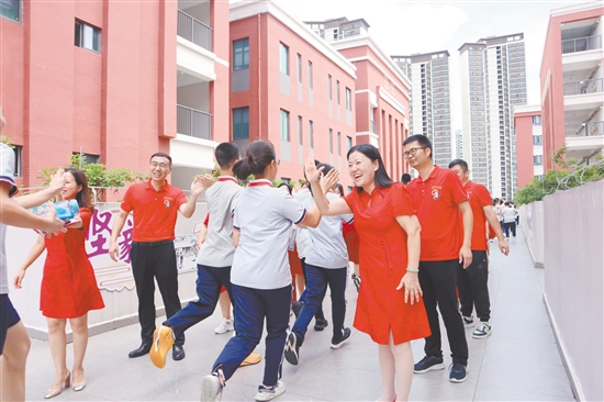 蓬江區(qū)紫茶中學(xué)的領(lǐng)導(dǎo)和老師們與考生們擊掌，為他們加油、鼓勁。