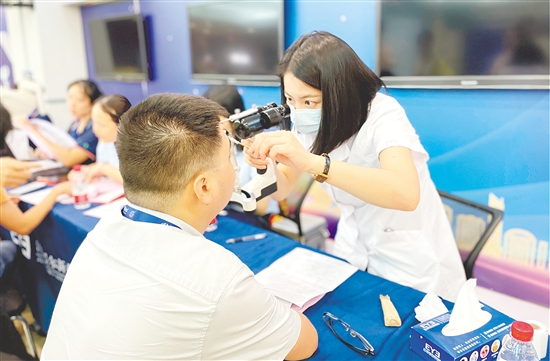 醫(yī)護(hù)人員為企業(yè)職工檢查眼睛。