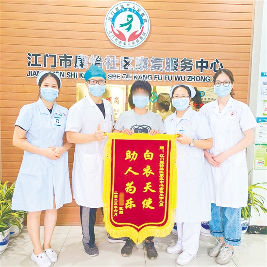 李明給康復(fù)中心醫(yī)護(hù)人員送上錦旗。