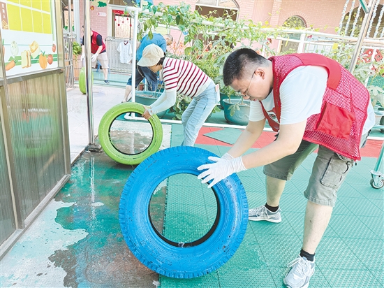 蓬江區(qū)委組織部干部深入幼兒園清理輪胎內(nèi)積水，做好基孔肯雅熱疫情防控工作。