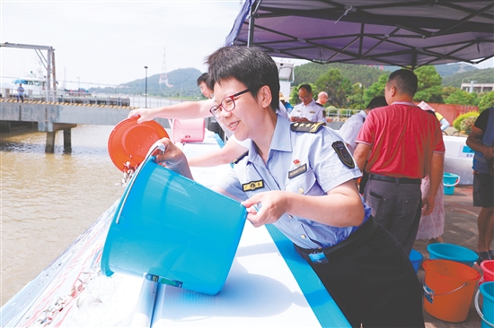 工作人員將魚苗、蝦苗倒入滑道。