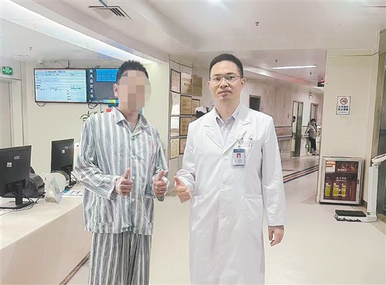 患者和醫(yī)生合影，豎起大拇指表示肯定。