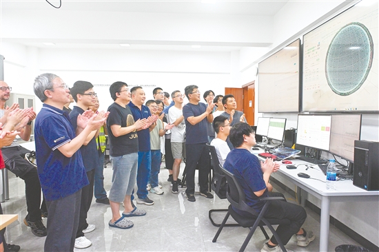 8月26日，科研人員在江門(mén)中微子實(shí)驗(yàn)運(yùn)行控制室共同開(kāi)啟物理取數(shù)，鼓掌慶祝取數(shù)成功。