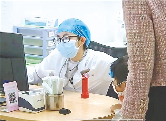 醫(yī)生向患兒及家長了解情況。