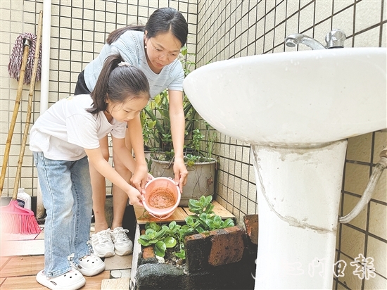 學(xué)生和家長(zhǎng)一起清理家中積水。