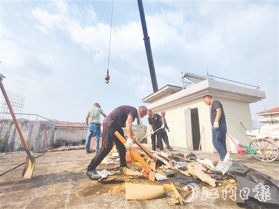 志愿者上門(mén)清理居民樓天臺(tái)的垃圾。