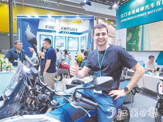 在江門市珠峰摩托車有限公司展位，外國客商前來了解摩托車新品情況，并為產(chǎn)品點贊。張澤彬