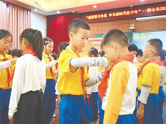 活動中，老隊員熟練地為新隊員系上紅領巾。