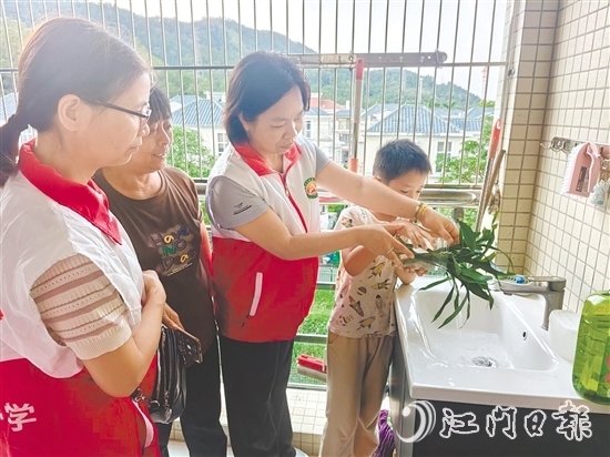 恩平市鰲峰小學(xué)黨員教師入戶指導(dǎo)學(xué)生清積水。