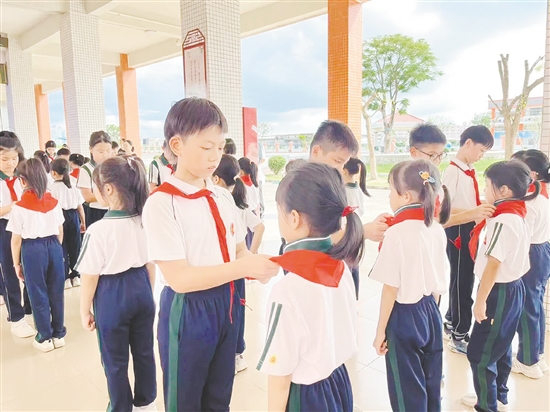 儀式上，老隊員為新隊員戴上鮮艷的紅領巾。