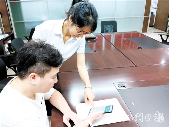 工作人員在指導(dǎo)市民線上交存住宅專項維修資金。陸沿任