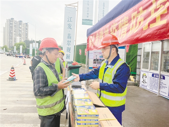 工地施工人員排隊(duì)領(lǐng)取防蚊用品。